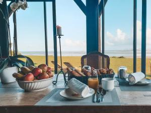 a table with a bowl of apples and a basket of fruit at "La Girelle, bord de mer" in Honfleur