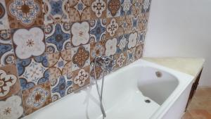 eine Badewanne in einem Badezimmer mit Fliesen an der Wand in der Unterkunft Cyprus Village House in Kyrenia