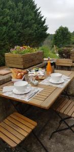 einem hölzernen Picknicktisch mit Teller mit Essen drauf in der Unterkunft Les Granges Indigo in Fossemagne