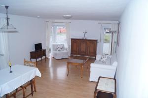 sala de estar con muebles blancos y mesa en Weingut Landmann Ferienwohnungen, en Freiburg im Breisgau
