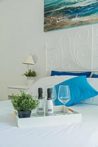 a tray with bottles and wine glasses on a bed at River View in Fiumicino