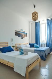 three beds in a room with blue curtains at River View in Fiumicino