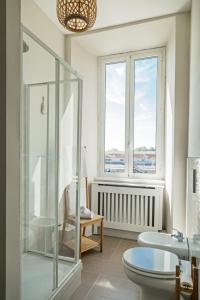 a bathroom with a shower and a toilet and a window at River View in Fiumicino