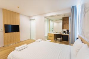 a bedroom with a white bed and a bathroom at Artino Hotel - SHA Extra Plus in Bangkok
