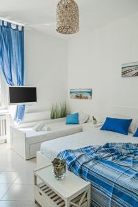 two beds in a white room with blue pillows at River View in Fiumicino