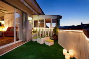 a small balcony with green grass and candles on it at Atic Gaudi-Gracia in Barcelona