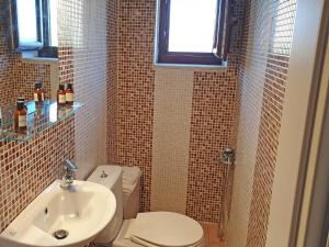 a bathroom with a toilet and a sink at Anaroussa Diros Maisonette in Areopoli