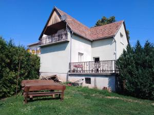 a white house with a balcony and a bench at VIL'LAGUNA Apartment with view of Balaton in Zánka