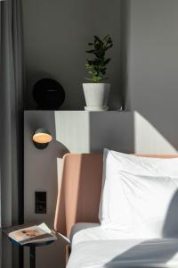 a white bed with a plant on top of it at Conscious Hotel Museum Square in Amsterdam