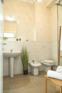a white bathroom with a sink and a toilet at River View in Fiumicino