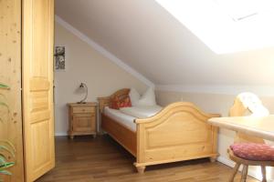 a small bedroom with a bed and a table at Pension Weindl in Notzing