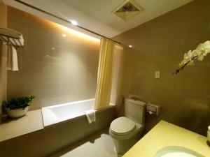 La salle de bains est pourvue de toilettes, d'un lavabo et d'une baignoire. dans l'établissement Saigon Hotel Dong Du, à Hô-Chi-Minh-Ville