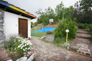 a garden with a house and a fence at Chuchi Guest House 1 in Zlatna Panega