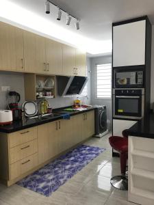 uma cozinha com armários de madeira e um tapete azul em Wan Homestay Putra Impian em Kajang