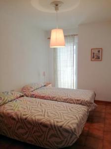 duas camas sentadas num quarto com um candeeiro em El Medano - Cerca de la Playa em El Médano