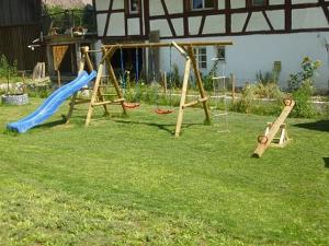 a playground with a slide and a swing set in a yard at Apfelhof - Ferienwohnung Wielath in Salem