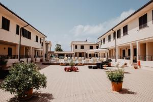 a courtyard of a building with chairs and trees at Residence Talamone Il Poderino in Talamone