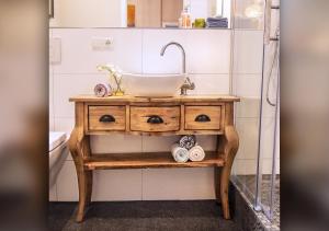 a bathroom with a wooden vanity with a sink at Comfort and Style in City Center with Ensuite Bathroom on Schaafenstraße in Cologne