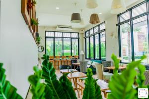a room with tables and chairs and windows at La Riva Boutique Hotel in Kamphaeng Phet