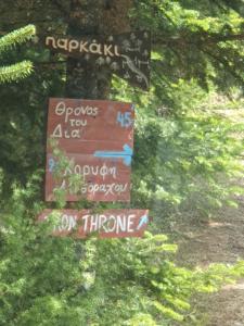 un grupo de carteles en un árbol en el bosque en Mountain Villa en Graviá