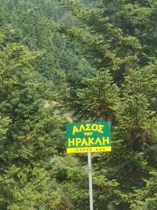 un signo de nxos delante de un árbol en Mountain Villa en Graviá