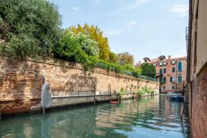 ヴェネツィアにあるVe.N.I.Ce Cera Remer Suiteの煉瓦の壁の横の運河の船