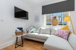 ein Wohnzimmer mit einem Sofa und einem TV in der Unterkunft Oxfordshire Living - The Lewis Apartment - Oxford in Oxford