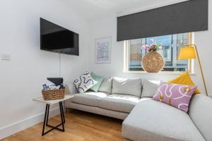 a living room with a couch and a tv at Oxfordshire Living - The Lewis Apartment - Oxford in Oxford