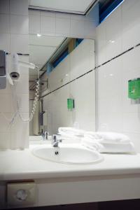 a white bathroom with a sink and a mirror at Fletcher Hotel Restaurant De Wipselberg-Veluwe in Beekbergen