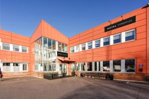 an orange building with a parking lot in front of it at Hotel Vindeus in Södertälje