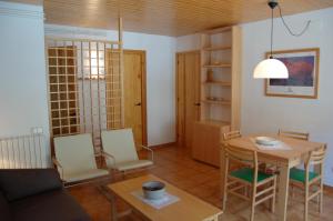 sala de estar con mesa y sillas y comedor en Apartaments Vall Ferrera, en Àreu