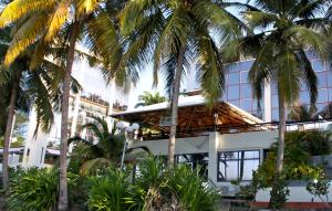 un edificio con palme di fronte di Karibea Squash Hôtel a Fort-de-France Altre 37 foto