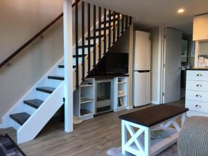 a living room with a staircase and a table at Beynon&Bolton’s Country Loft Escape in Katikati