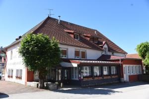 a white building with a red roof at Logis Hôtel Restaurant Barrey in Orchamps-Vennes