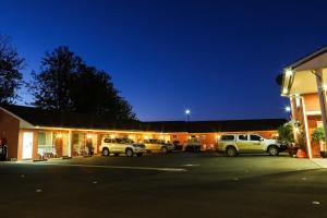 parking przed budynkiem z zaparkowanymi samochodami w obiekcie Akuna Motor Inn and Apartments w mieście Dubbo