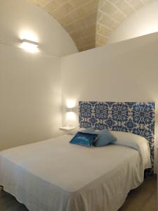 a bedroom with a bed with blue and white sheets at la casetta in Favignana