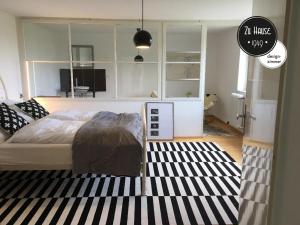 1 dormitorio con cama y alfombra blanca y negra en Zu Hause 1949 en Markdorf