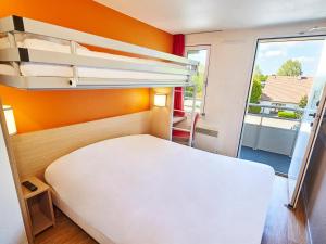 ein Schlafzimmer mit einem Bett und einem großen Fenster in der Unterkunft Première Classe Melun Senart in Vert-Saint-Denis