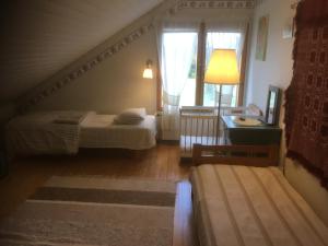 a bedroom with two beds and a staircase with a window at Farmholiday Kumpunen in Petäjävesi