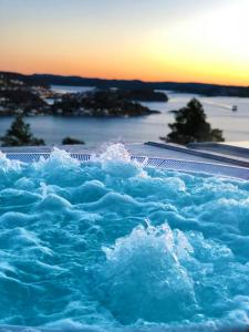 a pool of water with the ocean in the background at Kragerø Resort in Stabbestad