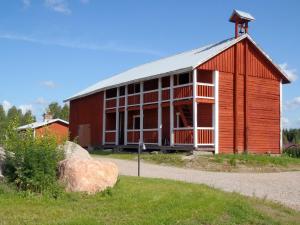 um grande celeiro vermelho com um gambrel em Farmholiday Kumpunen em Petäjävesi