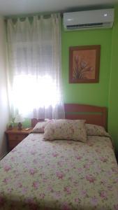 アロヨ・フリオにあるAlojamientos Las Lachasのベッドルーム1室(花柄のベッドカバー、窓付)