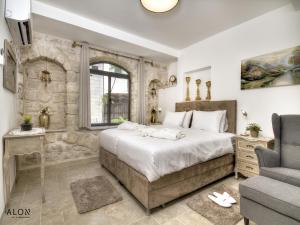 a bedroom with a large bed and a stone wall at אצולת הכיכר a in Safed