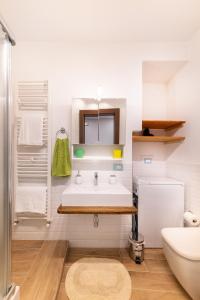 ein weißes Badezimmer mit einem Waschbecken und einem Spiegel in der Unterkunft Le casette di nonno Pippo in Palazzolo Acreide
