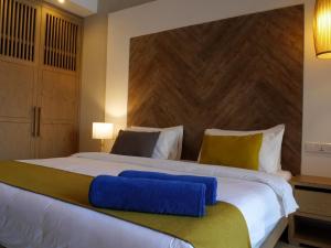 a bedroom with a large white bed with a wooden headboard at African Princess Beach Hotel in Serekunda