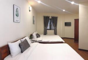 Cette chambre comprend 2 lits et une télévision. dans l'établissement Le Grey Dalat Hotel, à Đà Lạt