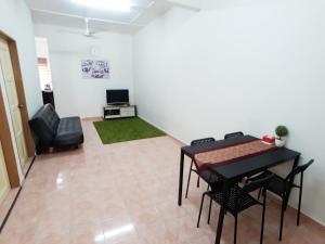 a living room with a table and a chair at JJ Melaka Holiday home in Melaka