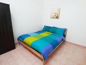 1 dormitorio con 1 cama con una manta colorida en JJ Melaka Holiday home, en Melaka
