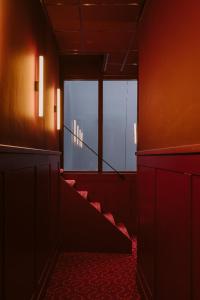 
a red stairway leading to a dark room at Supernova Hotel in Rotterdam
