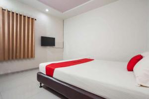 1 dormitorio con 1 cama y TV en la pared en RedDoorz @ Panglima Sudirman, en Surabaya